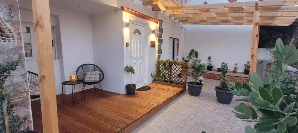 a porch with potted plants and a white door at The Nook in Maleme