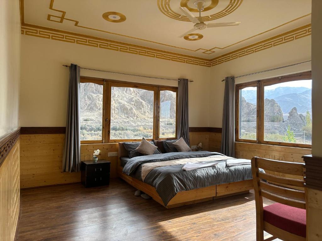 a bedroom with a bed and two large windows at Blue Yak Resort in She