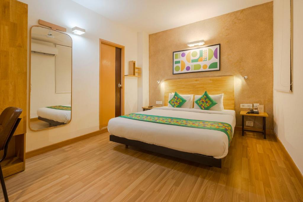 a hotel room with a large bed and a mirror at Treebo Ace Luxe in New Delhi
