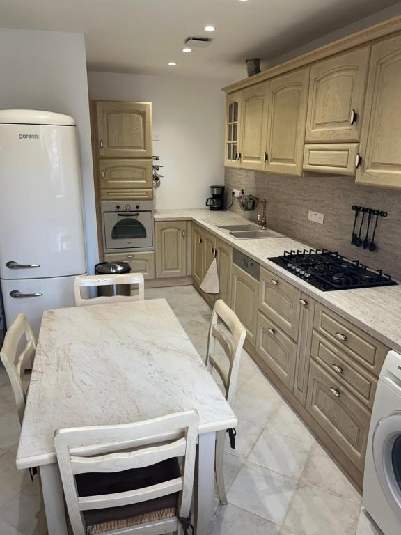 a kitchen with wooden cabinets and a table with chairs at gîte des gorges de Daluis appartement 2 pieces in Daluis