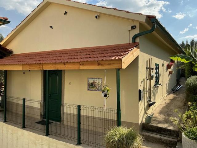 a small house with a green door and a fence at Manor Meeder in Castanheira de Pêra