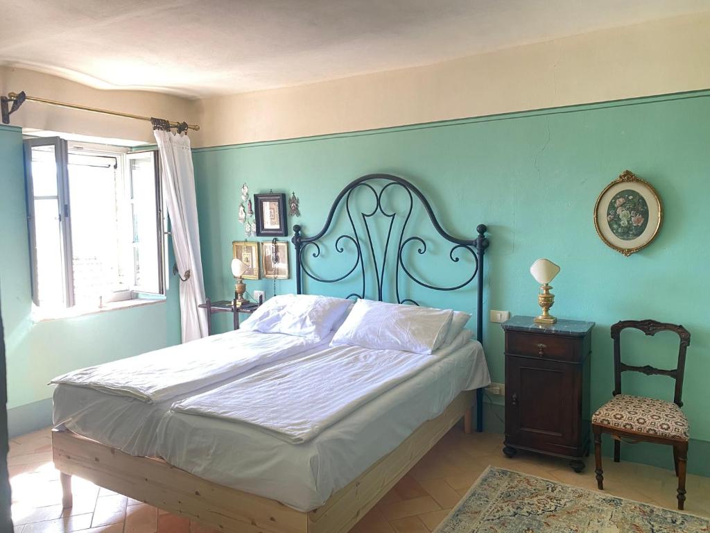 a bedroom with a large bed and a chair at Casa Rosmarino Malgrate in Filetto