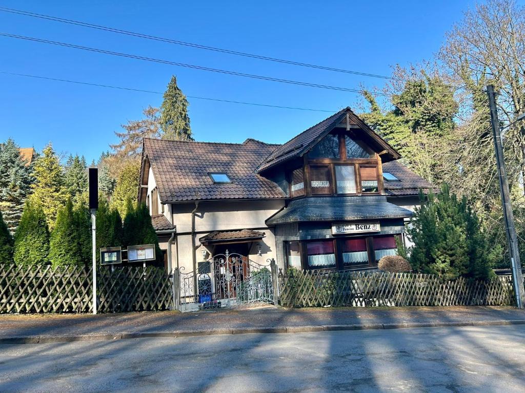 a large house with a fence in front of it at Benz Café & Pension in Blankenburg