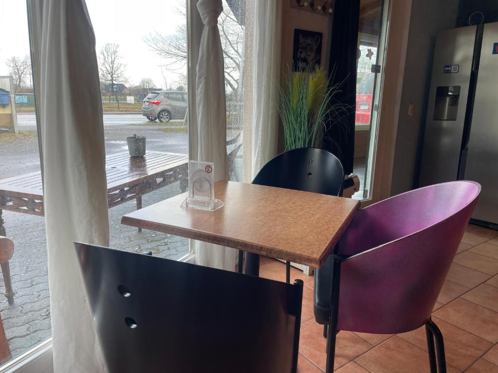 a table and two chairs in front of a window at Pension Hammoor in Hammoor