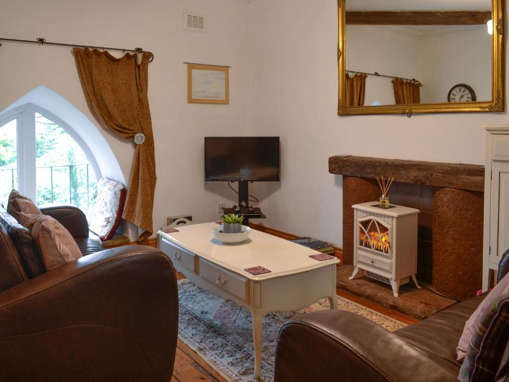a living room with a couch and a fireplace at 5 Church Square in Rigg