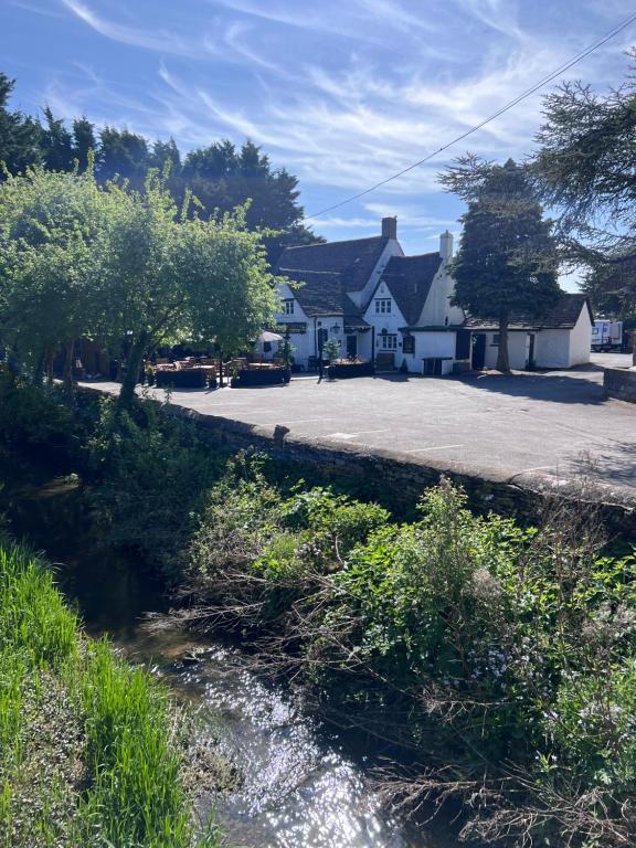 a house next to a road and a river at The loft in Cirencester
