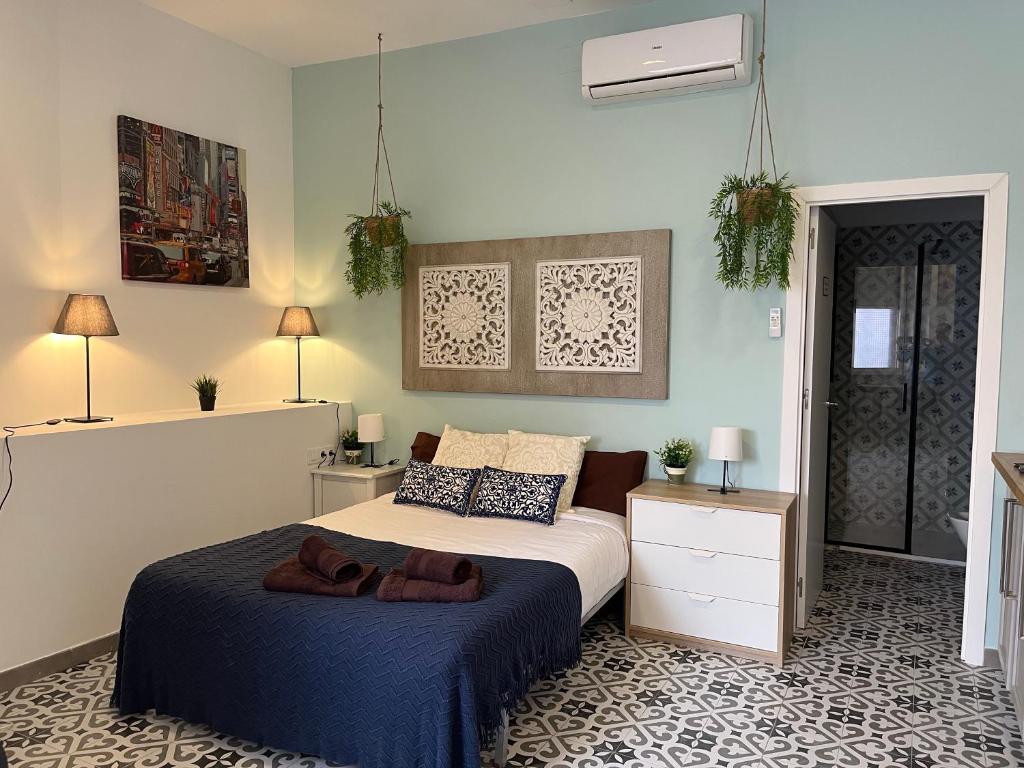 a bedroom with a large bed with a blue blanket at INT Studio totalmente equipado, 15' de BCN centro 8' playa in Sant Adria de Besos