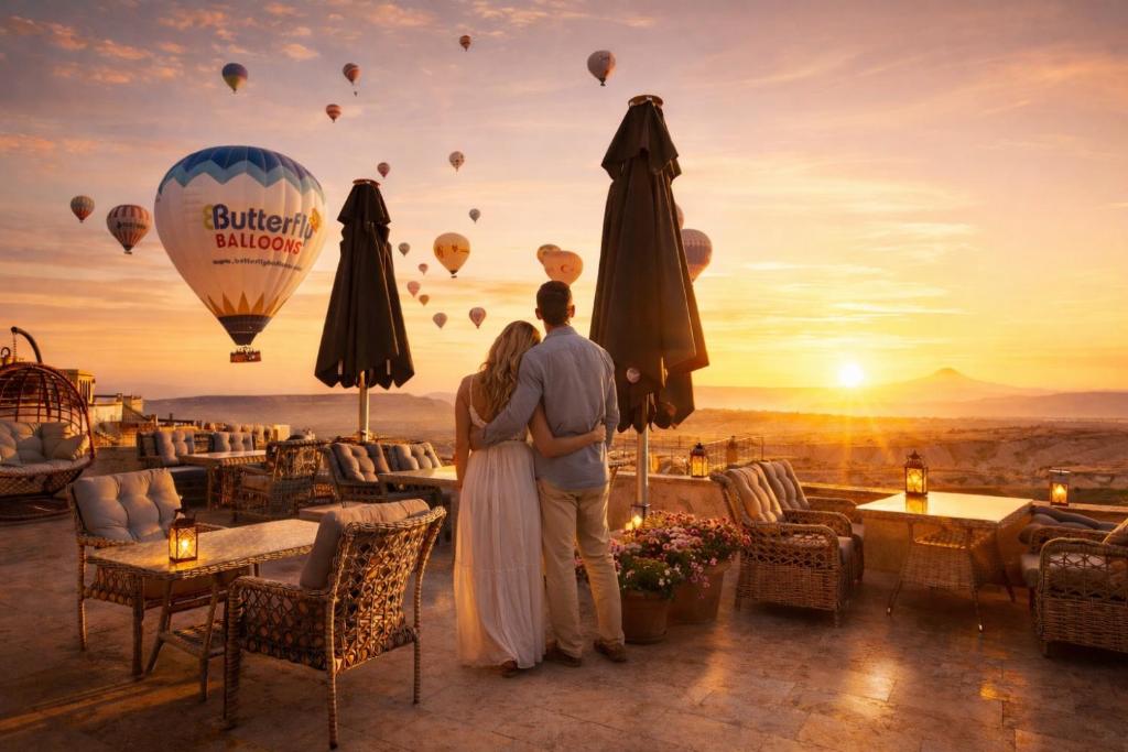 a man and woman standing in front of a hot air balloon at Cappadocia Pegasos Cave Suite Hotel in Uçhisar