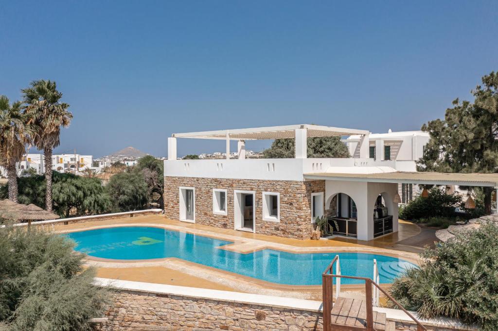 a house with a swimming pool in front of it at Plaka Hotel II in Plaka