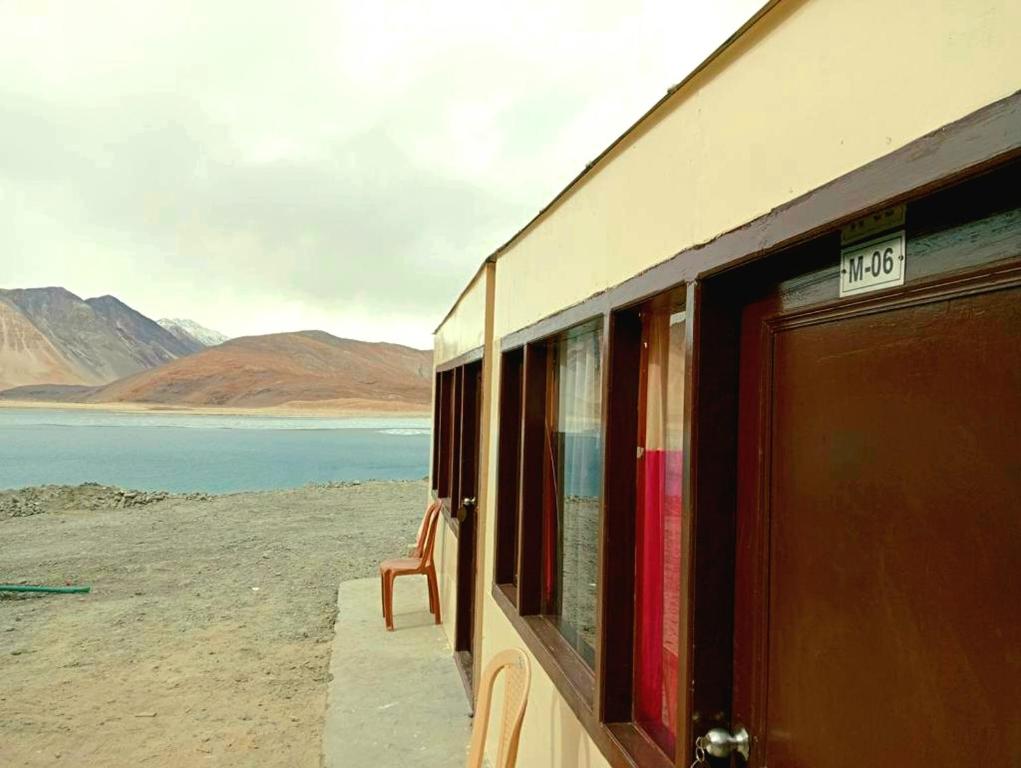 a train window with a view of a body of water at Pangong Mentsel Cottage in Lukung