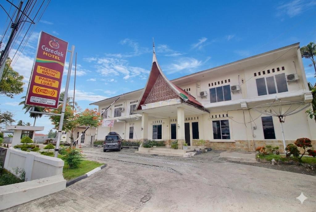 ein Gebäude mit einem Schild davor in der Unterkunft Hotel Caredek in Solok