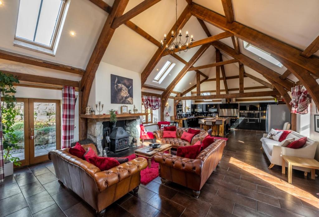 a living room with leather couches and a fireplace at The Hideaway in Banchory
