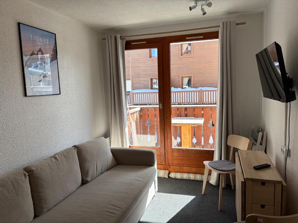 a living room with a couch and a sliding glass door at Studio Tignes Val Claret in Tignes