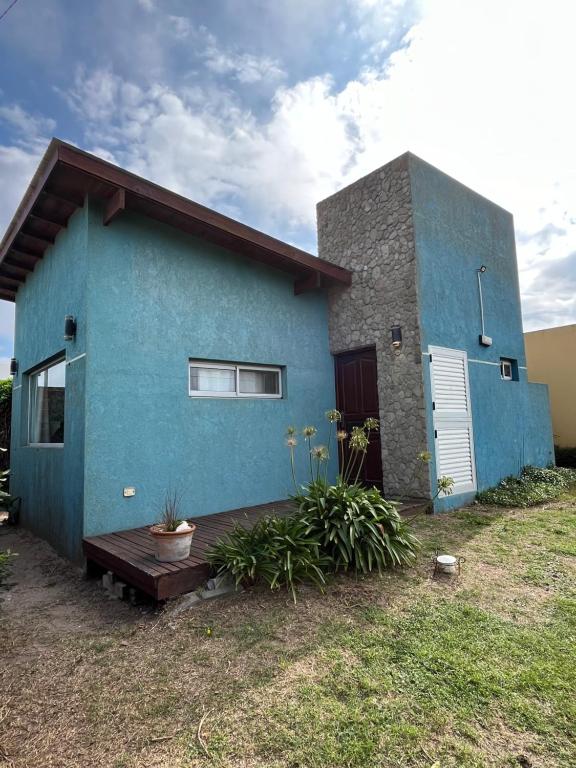 a blue house with a wooden deck in front of it at Ayres de Cobo in Mar de Cobo