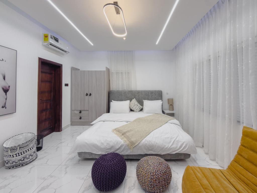 a bedroom with a large bed with two ottomans and a bedsenal at Serenity Suite in Accra