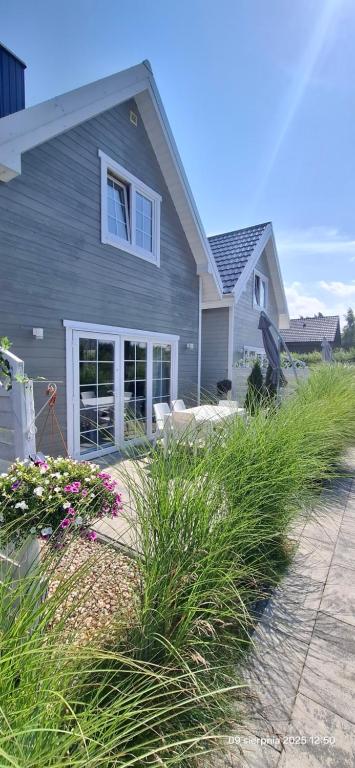 a gray house with some plants in front of it at Plażowisko in Dębki