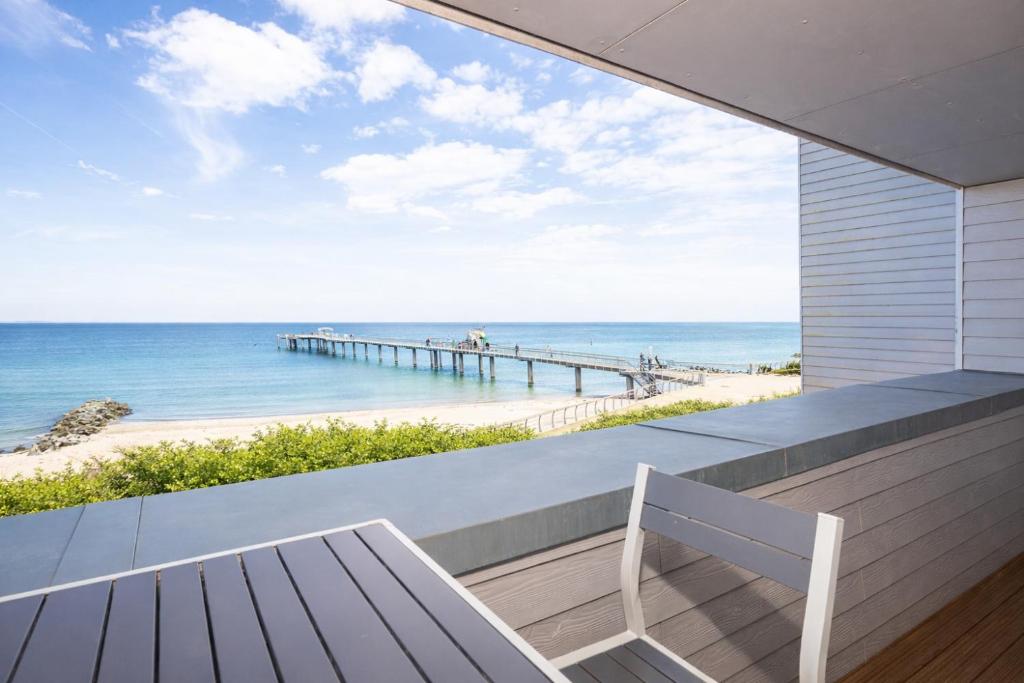 a balcony with a bench and a view of the beach at Ostsee Suite 3 - Strandperle in Niendorf