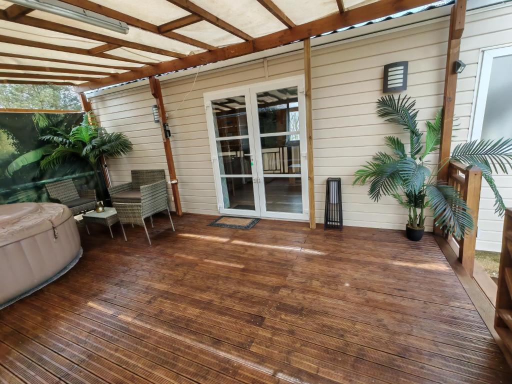 a screened in porch with a wooden deck at Le Havre de la jungle in Montereau