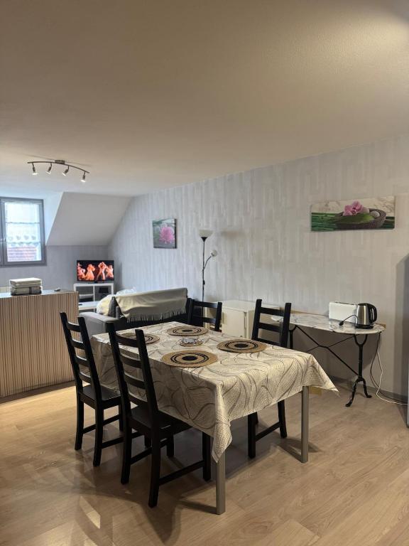 a dining room with a table and chairs in a room at Studio confortable proche thermes in Salins-les-Bains