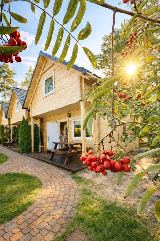 a house with a brick driveway in front of it at Morska Fala Domki in Pobierowo