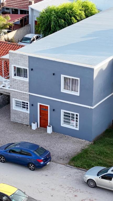 ein blaues Haus mit einem davor geparkten Auto in der Unterkunft Luarca 80 in Santa Clara del Mar