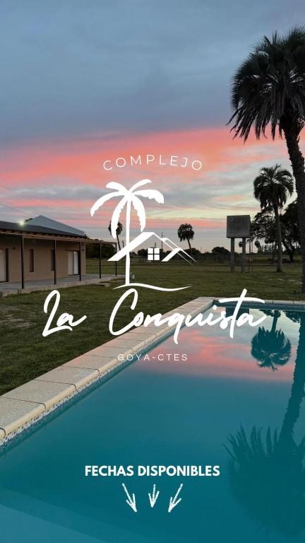 a sign for a resort with a pool and palm trees at Cabaña La Conquista in Goya