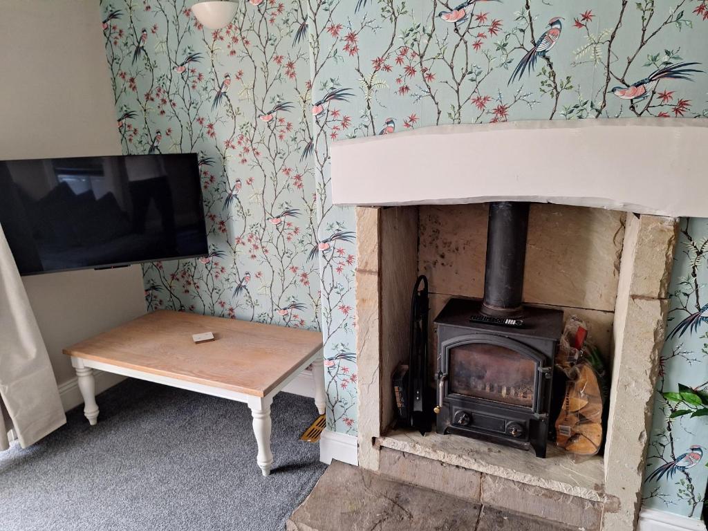 a wood stove in a living room with a tv at Fieldside House Beautiful Sleeps 6 House with Decked Garden in Scarborough