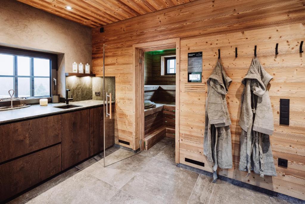 a bathroom with wooden walls and a sink and a shower at Dillhof Apartments in Eschau