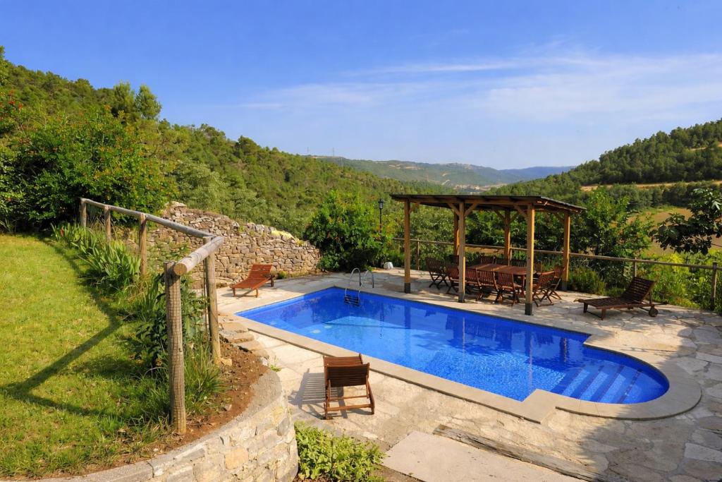 a swimming pool with a gazebo next to a hill at Casa con piscina y vistas a montaña - Cal Solsona in La Baronia de Rialb