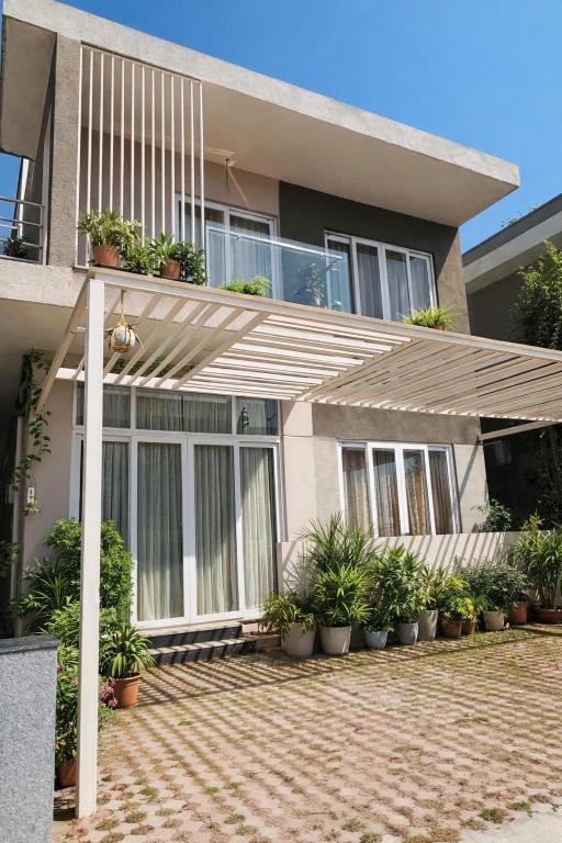a house with a wooden pergola in front of it at Premium Villa Stay Near the Airport Perfect for Families & Business Travelers in Hyderabad