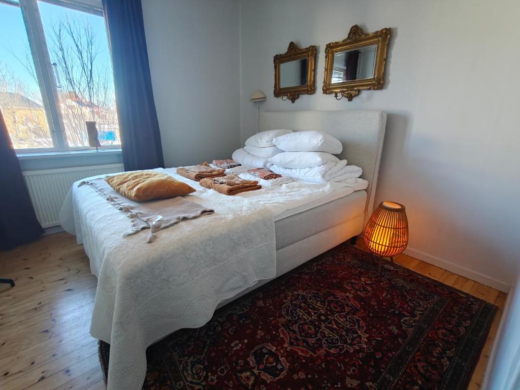 a bedroom with a bed with towels and a mirror at Rymlig 2-rumssvit nära Centralstationen - Anna Josefinas Stay in Umeå