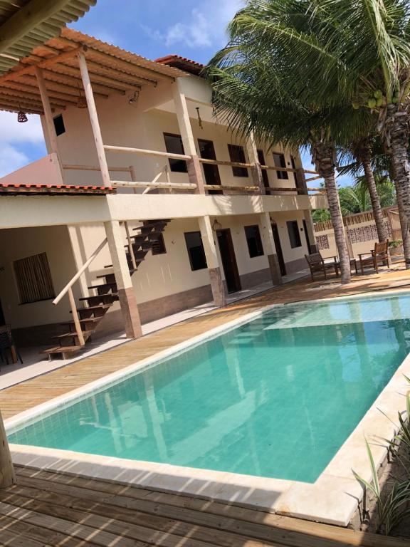 a swimming pool in front of a house at Pousada casa sonho do mar in Fortim