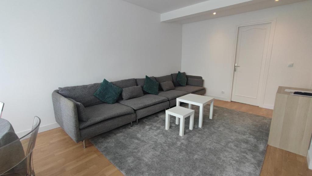 a living room with a couch and a table at Charming Bagneux Nest in Bagneux