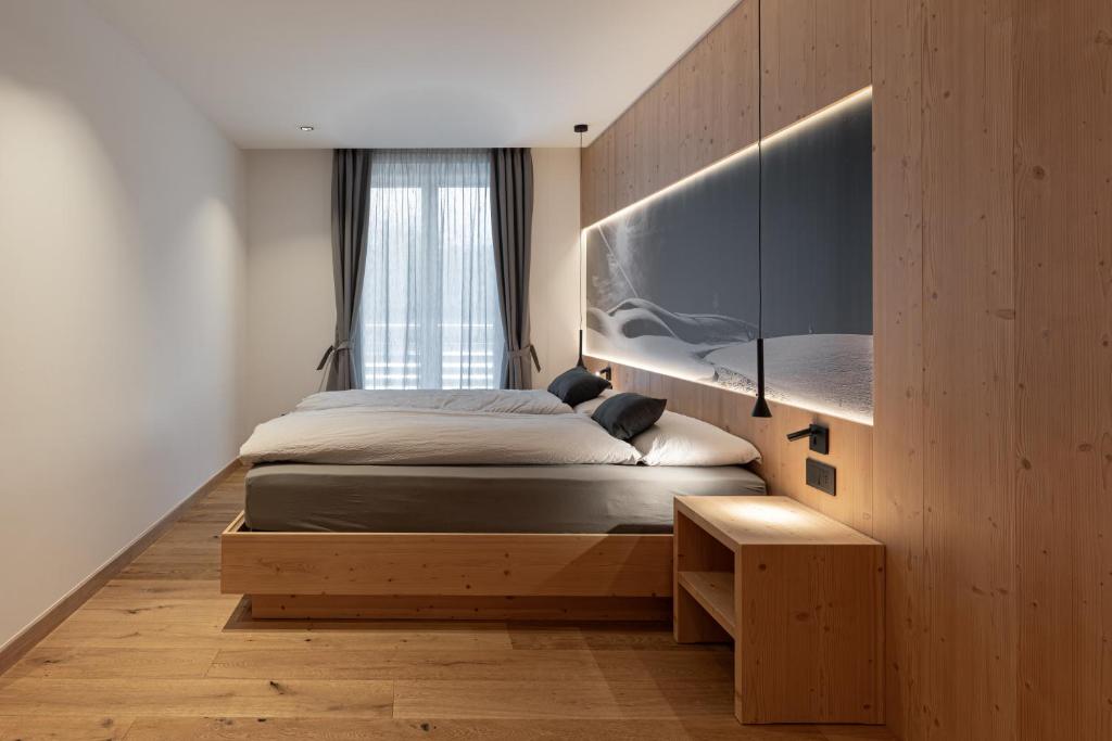 a bedroom with a bed and a large window at Appartamento Erica in Andalo