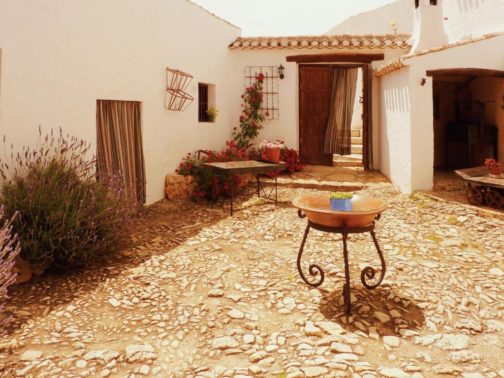a stone courtyard with a table in front of a house at Vintage Farmhouse in Algarinejo with Terrace in Fuentes de Cesna