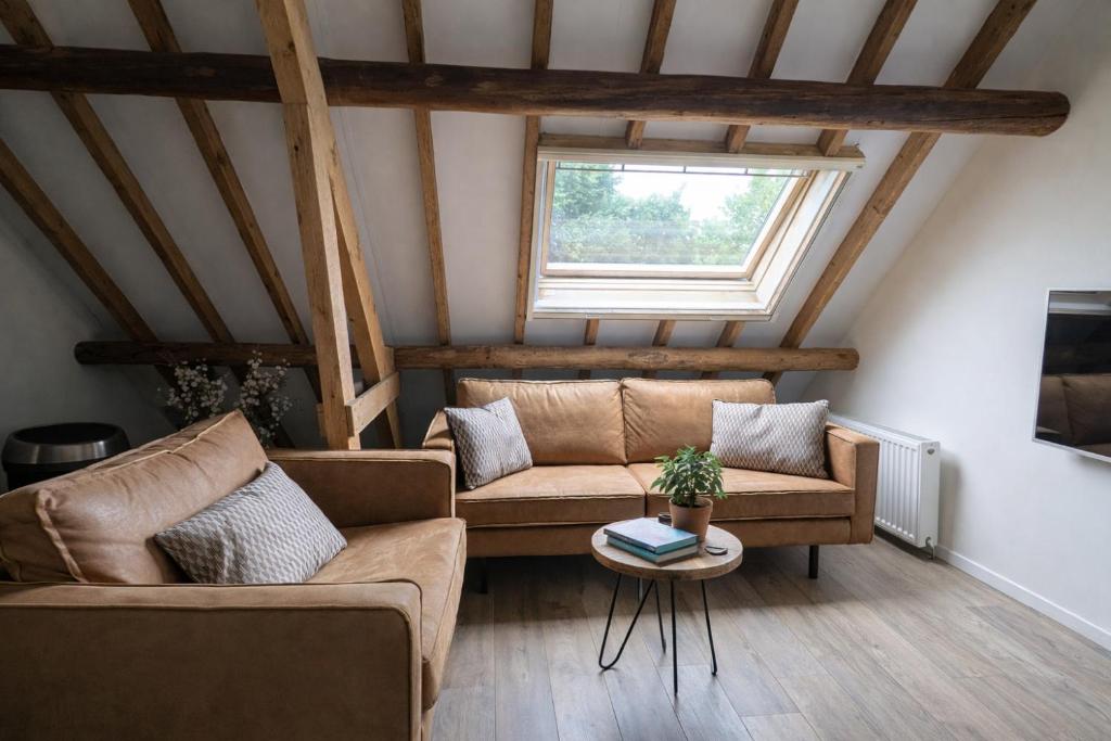a living room with two couches and a window at Ballumerhoeve Petit lodge in Ballum