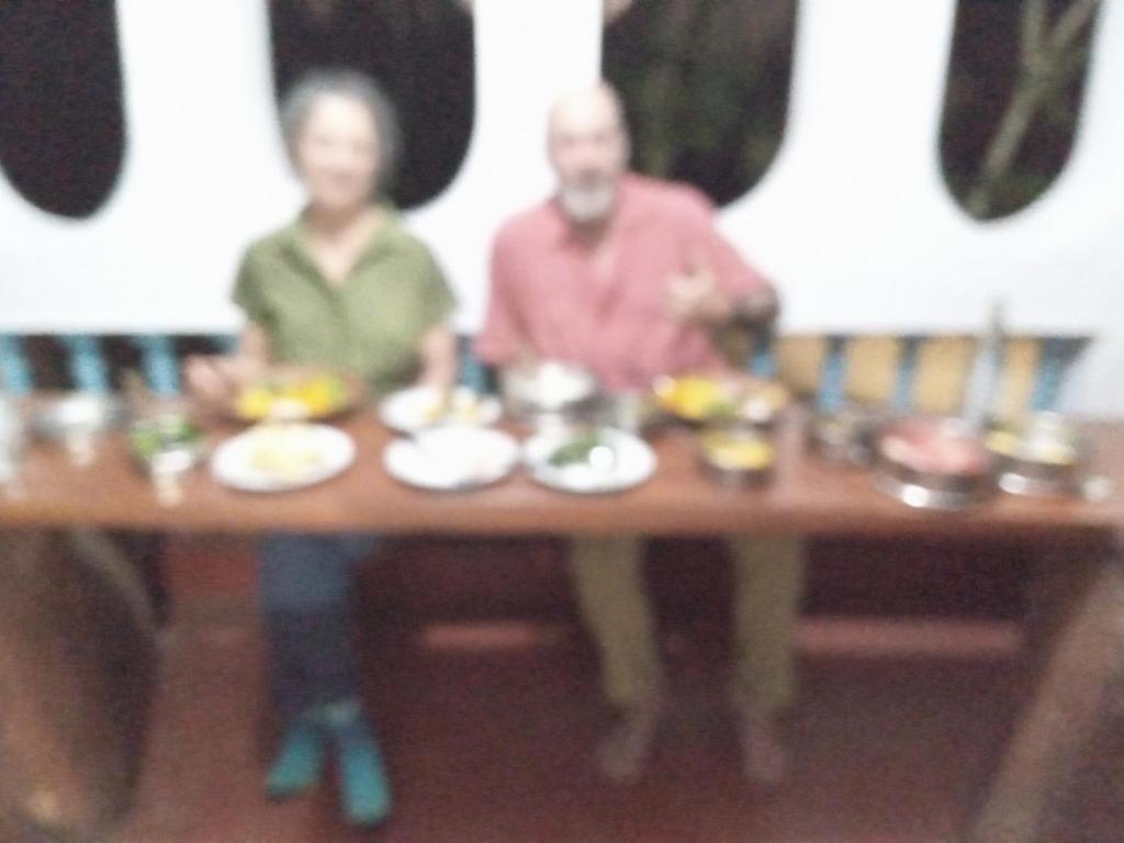 a man and a woman sitting at a table with food at Galoya Mahagedara in Inginiyagala