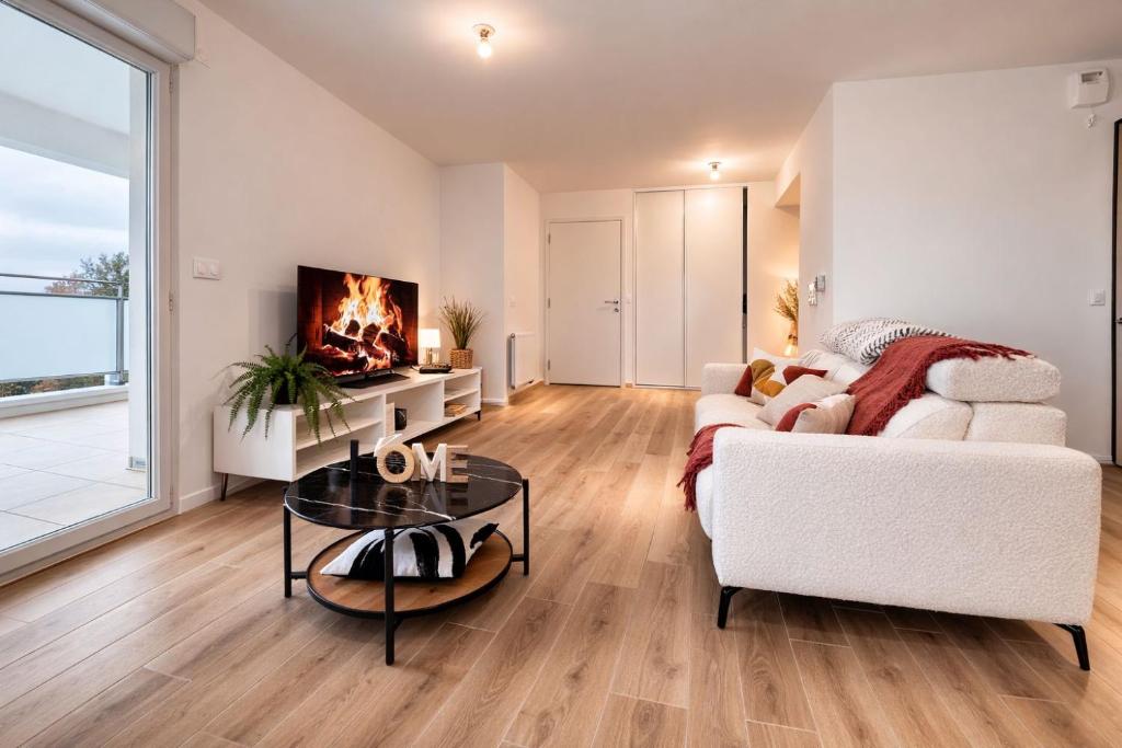 un soggiorno con un divano bianco e un camino di L'Instant Cocoon central-parking-4prs a Bourg-en-Bresse