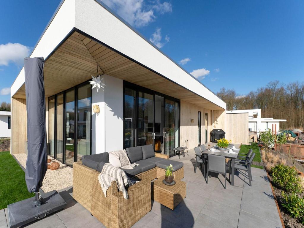 a patio with a couch and a table and chairs at Harderwold Villa - 412 in Zeewolde