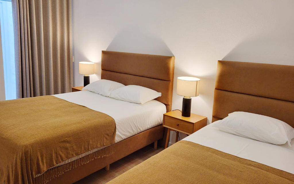a hotel room with two beds and two lamps at Casa João de Quintal in Elvas