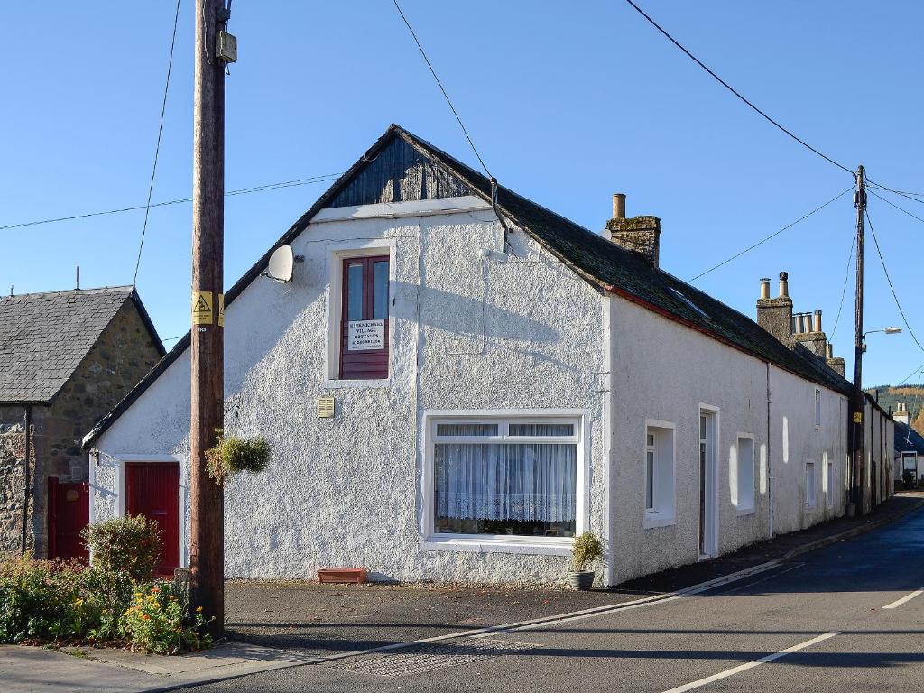 a white building on the side of a street at Macdonald Cottage in Balnald