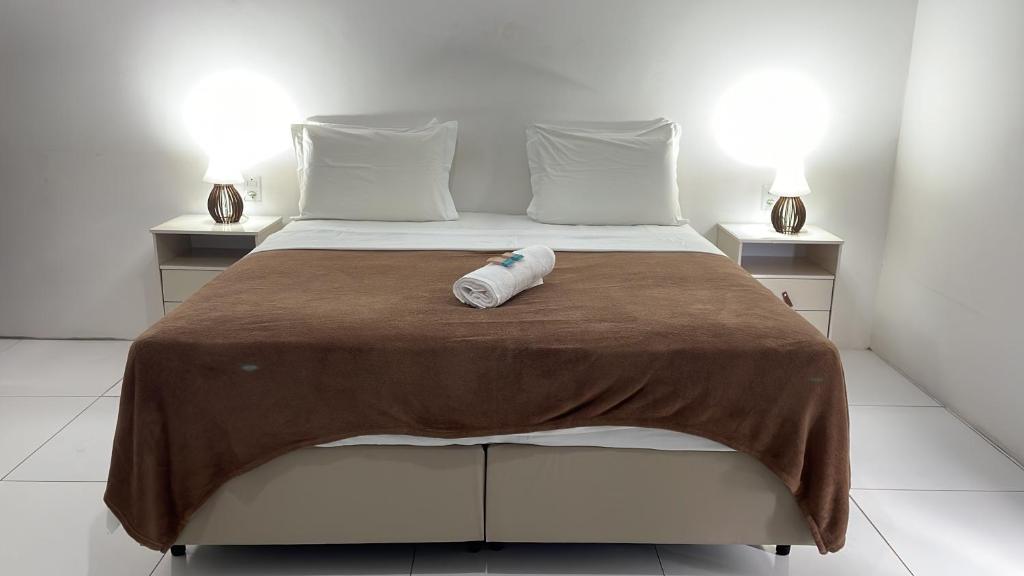 a bed with a bottle sitting on top of it at Casa do Val in Fernando de Noronha