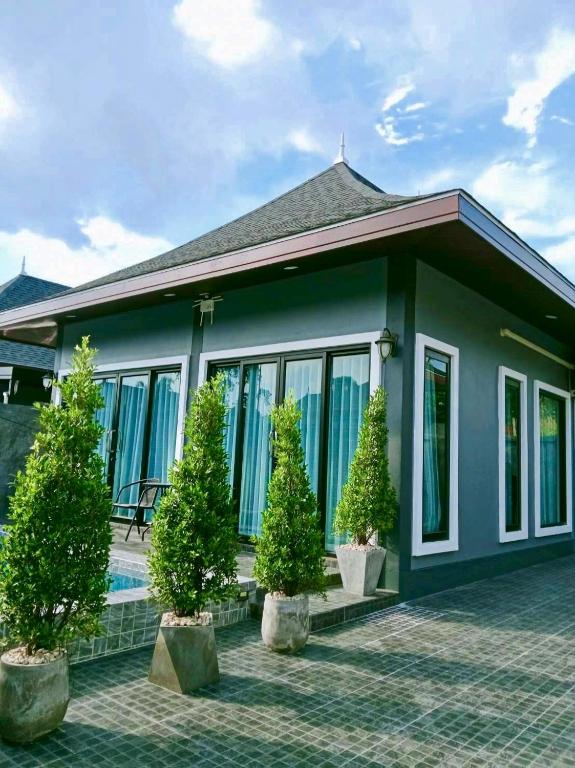 a house with trees in front of it at Aonang Homie Pool villa in Ao Nang 