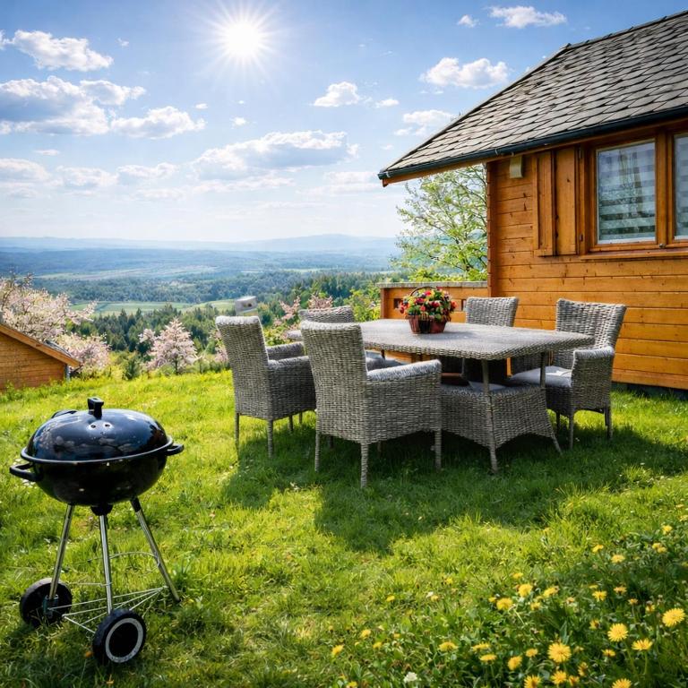 a bbq grill on the lawn of a cabin at Huberkowe Domki in Swiecko
