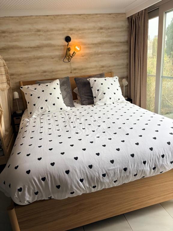 a bedroom with a large bed with black and white sheets at Le Ptit studio du vieux moulin in Rochefort