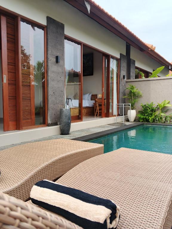a resort with a swimming pool and a villa at Umakami Pertiwi Villas in Ubud