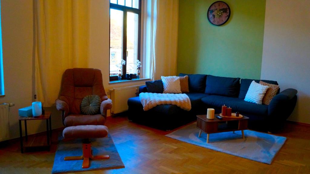 a living room with a blue couch and a chair at Ferienwohnung Hanna in Bitterfeld