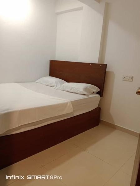 a small bedroom with a bed with white sheets at SHAMA HoTEL in Kuala Lumpur