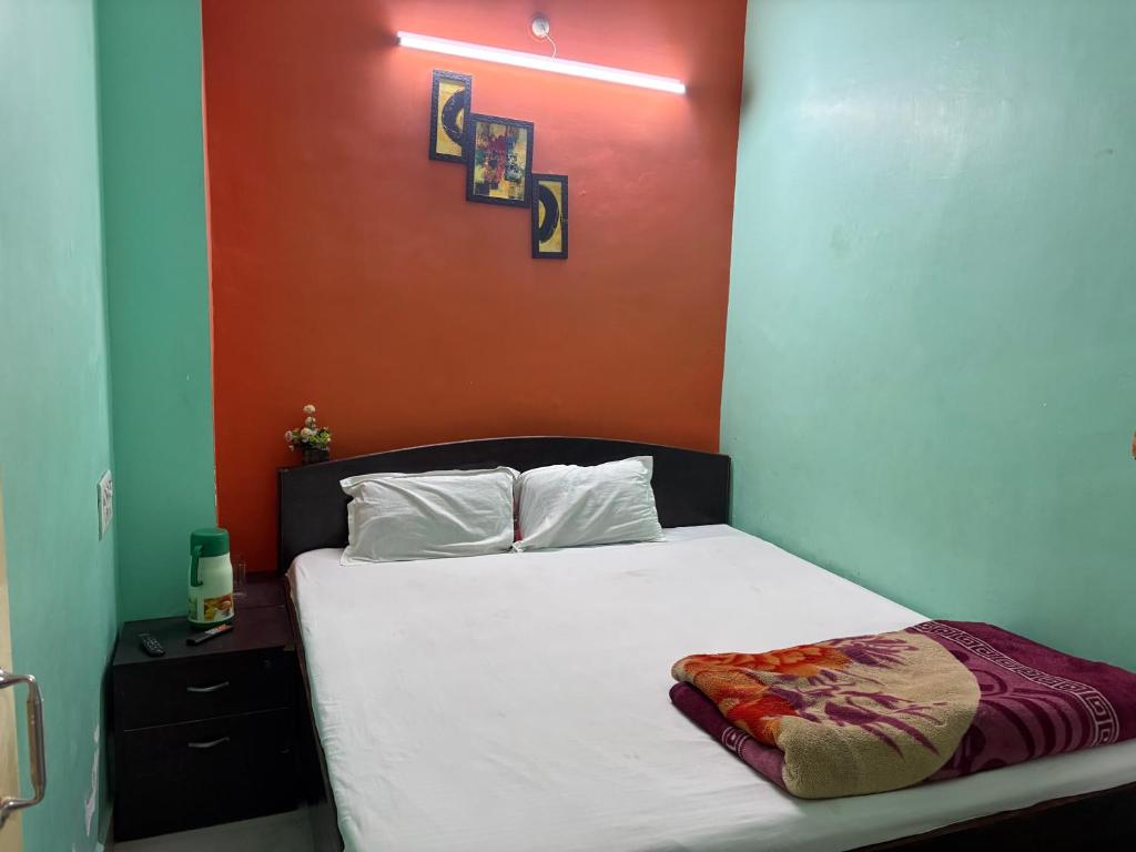 a bedroom with a white bed with a red wall at Hotel Baba Dx in Samastīpur