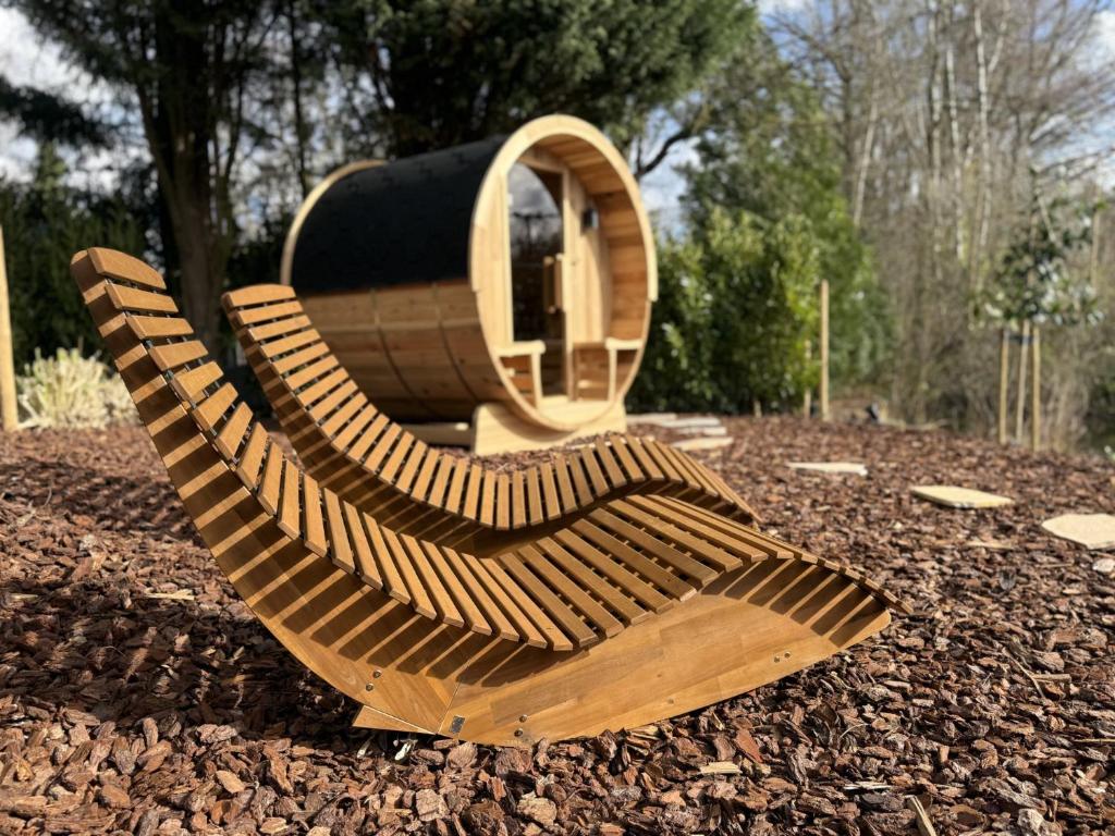 a wooden bench sitting on top of a pile of leaves at Wellness huisje Sonne Oase in Lanaken